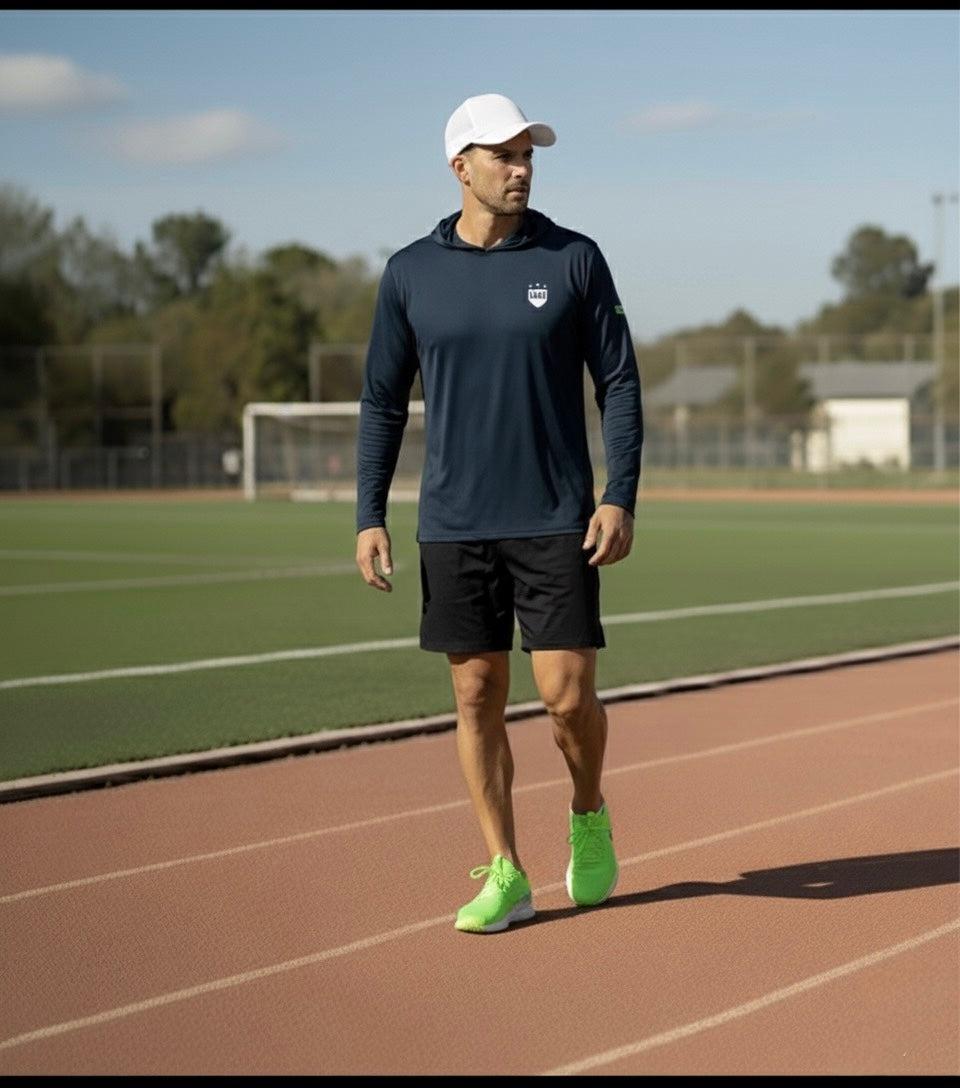 LIV.U Launch.KIT Performance long sleeve shirt on a runner at the track; navy top with logo, neon-green shoes, white cap.